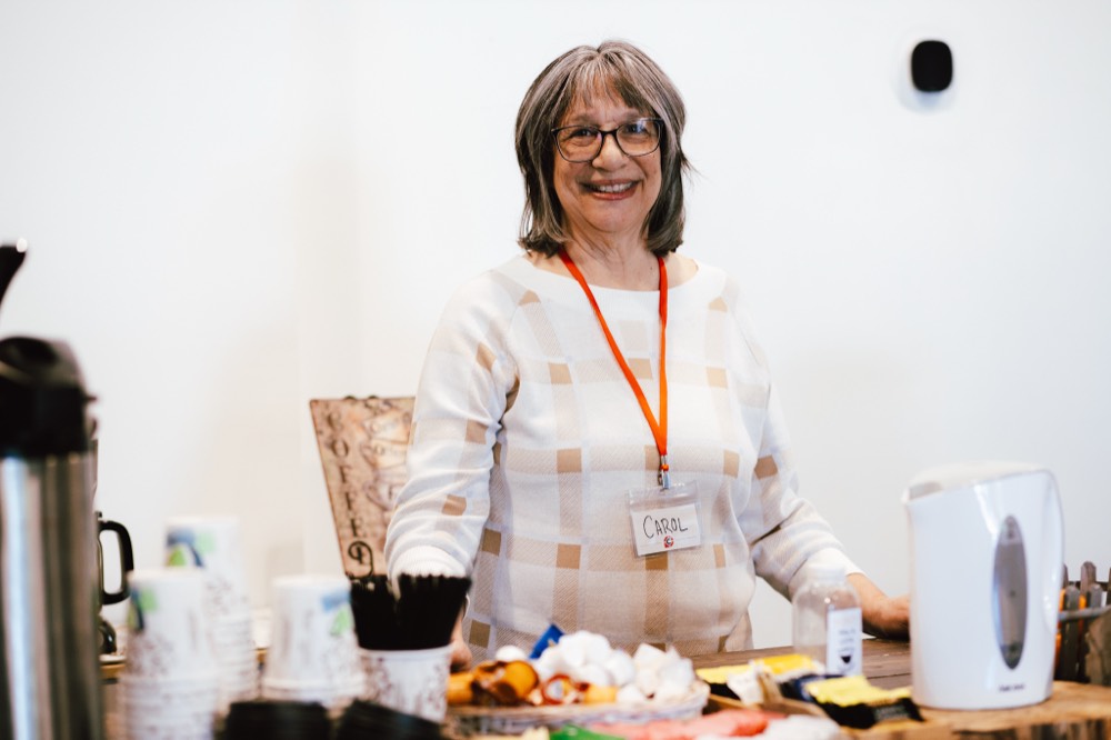 A volunteer smiling at the welcome table